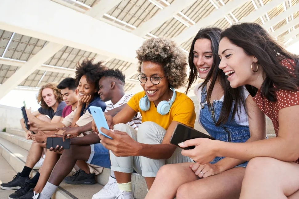 Group of people sitting together laughing outdoors